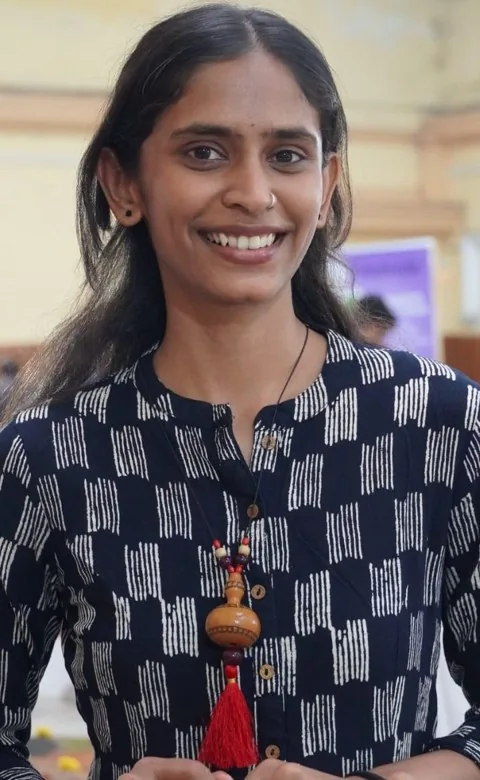Anarghya smiling, wearing the bottle-gourd necklace Ruthuparna's mom made
